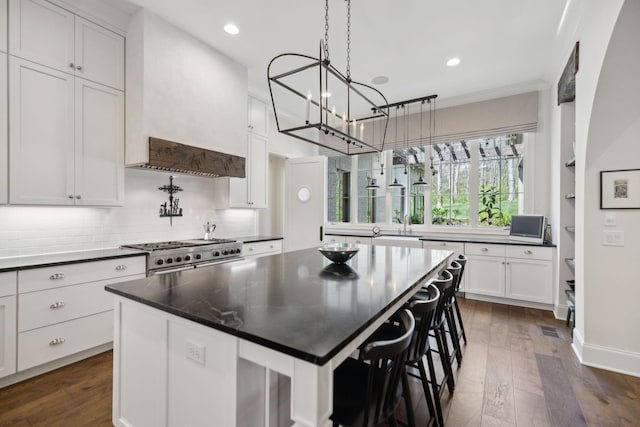 kitchen featuring a chandelier, dark wood-style floors, dark countertops, and range with two ovens