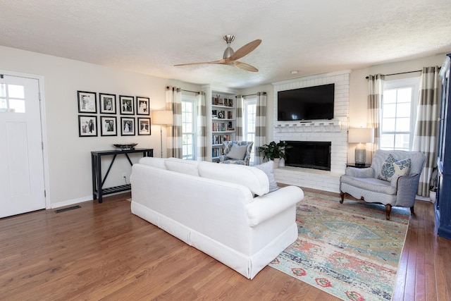 1411 Newmans Trl, Hendersonville, TN 37075 - living room with ceiling fan, wood finished floors, a textured ceiling, a fireplace, and baseboards