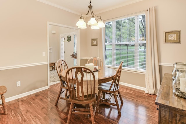 dining area with a chandelier, baseboards, crown molding, and wood finished floors