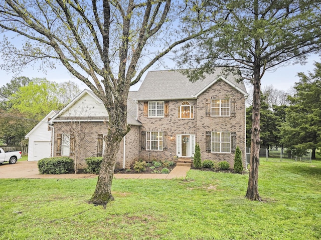 view of front of property featuring brick siding, a front lawn, fence, and a garage