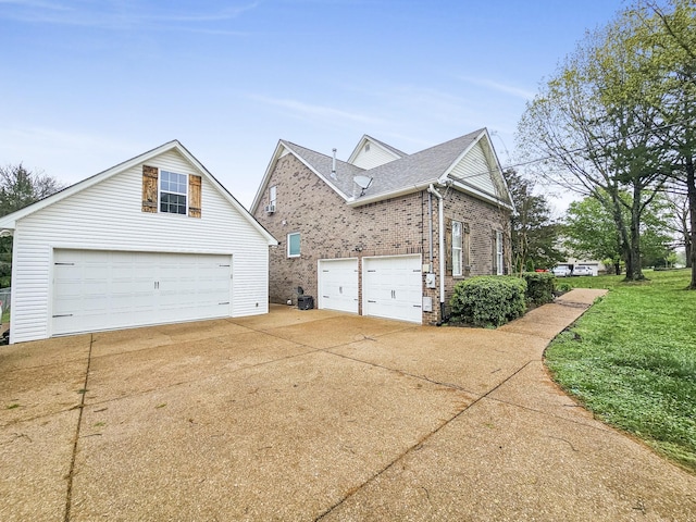 view of side of home featuring brick siding and concrete driveway