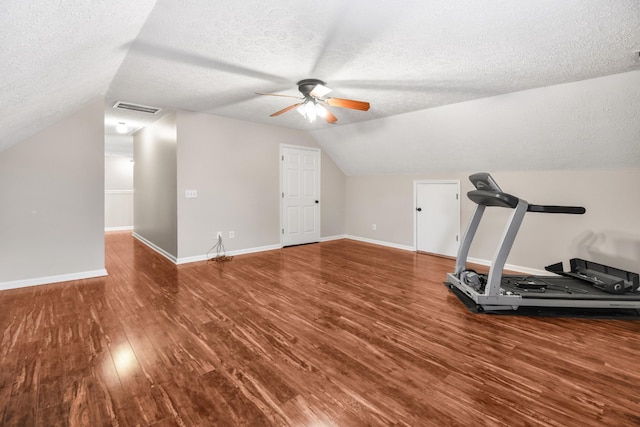 workout area with baseboards, a textured ceiling, a ceiling fan, visible vents, and wood finished floors