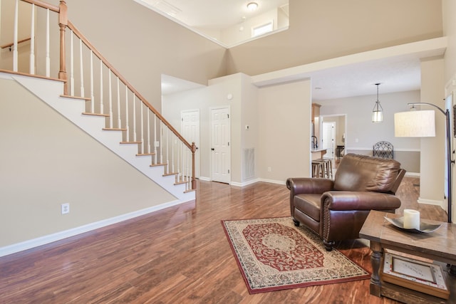 living room with visible vents, baseboards, and wood finished floors