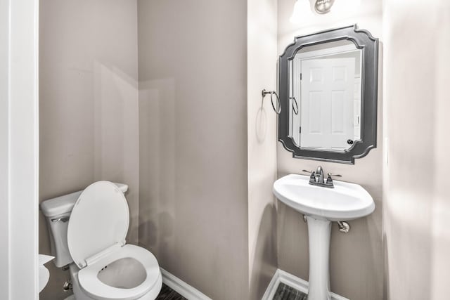 bathroom featuring toilet and baseboards