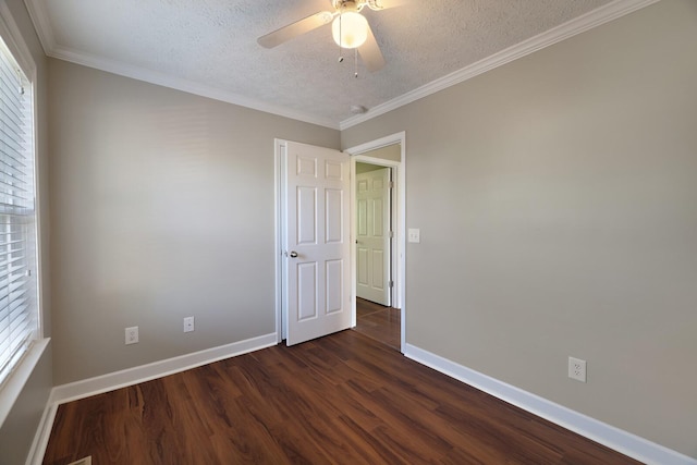 spare room featuring dark wood-style flooring, baseboards, ornamental molding, and a textured ceiling