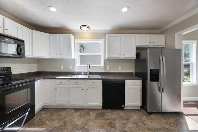kitchen with a sink, white cabinets, black appliances, and dark countertops