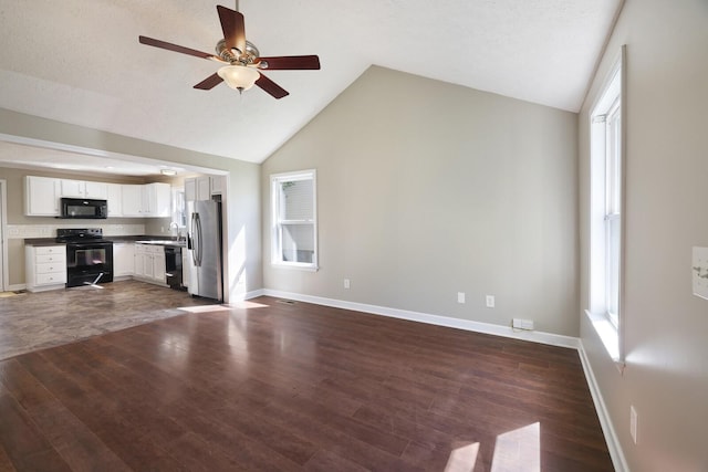 unfurnished living room with baseboards, dark wood-style floors, vaulted ceiling, and a ceiling fan