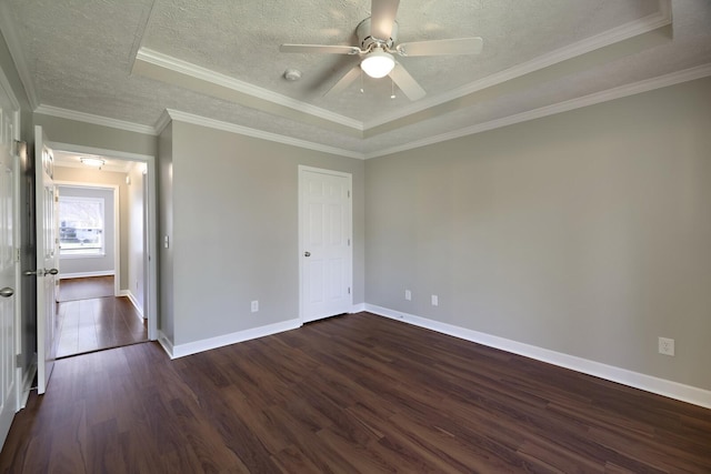 unfurnished bedroom featuring dark wood-style flooring, a tray ceiling, baseboards, and a textured ceiling