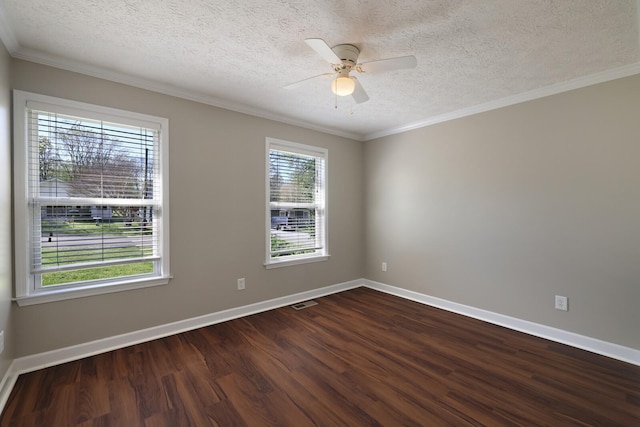 spare room with dark wood-style flooring, baseboards, crown molding, and ceiling fan
