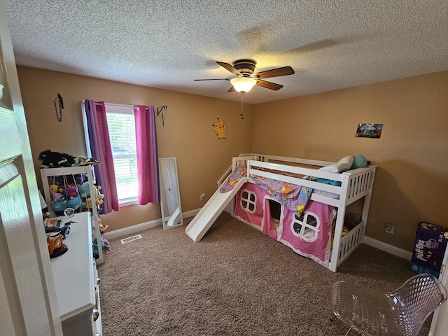 carpeted bedroom with baseboards, visible vents, ceiling fan, and a textured ceiling