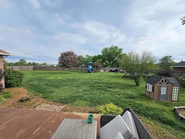 view of yard with a storage shed, an outbuilding, and a fenced backyard