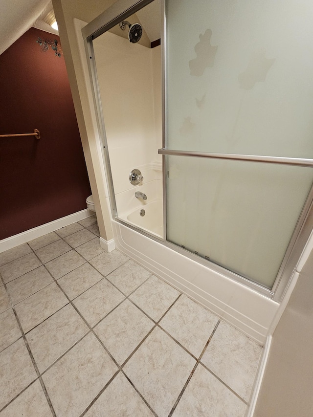 full bath featuring tile patterned floors, shower / bath combination with glass door, toilet, and baseboards