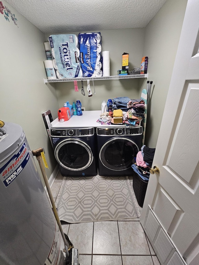 washroom with a textured ceiling, separate washer and dryer, and laundry area