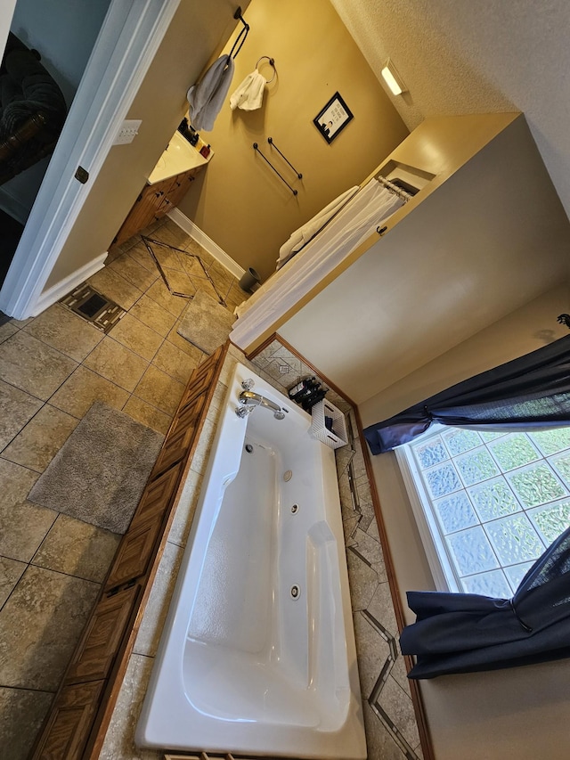 bathroom with baseboards and a jetted tub