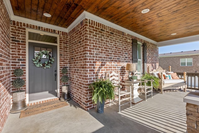 entrance to property with covered porch and brick siding