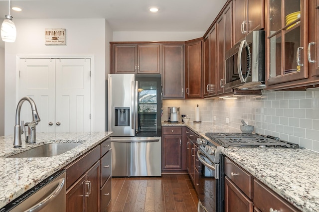 359 Mattieton Ln, Gallatin, TN 37066 - kitchen with light stone countertops, a sink, stainless steel appliances, decorative backsplash, and dark wood-style floors