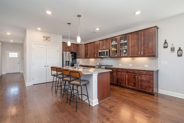 359 Mattieton Ln, Gallatin, TN 37066 - kitchen featuring stainless steel appliances, dark wood-type flooring, a breakfast bar area, and decorative backsplash
