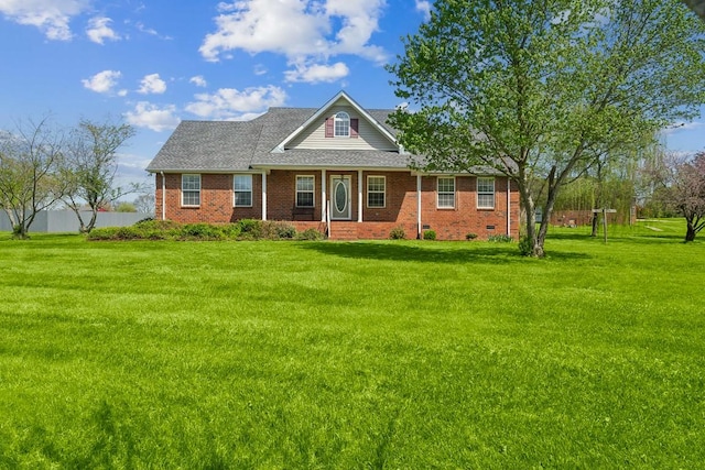 view of front of house with a shingled roof, brick siding, and a front lawn