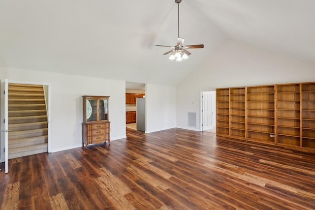 unfurnished living room with high vaulted ceiling, dark wood finished floors, a ceiling fan, visible vents, and baseboards