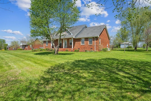 rear view of house with brick siding, crawl space, and a lawn