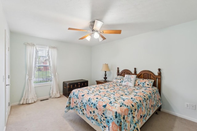 bedroom featuring light carpet, baseboards, a ceiling fan, and visible vents