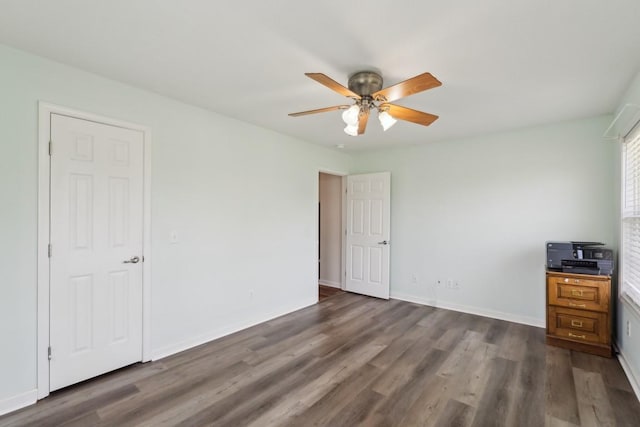 unfurnished bedroom featuring baseboards, ceiling fan, and dark wood-style floors
