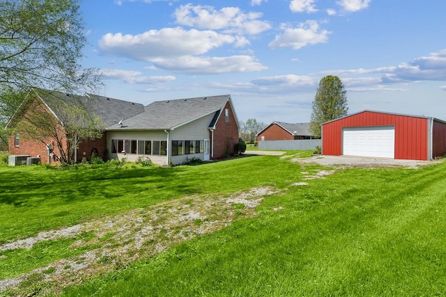 view of yard with a garage, driveway, and an outdoor structure