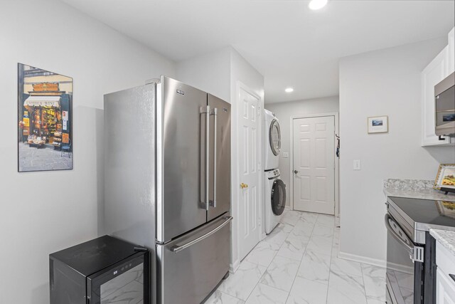 1304 Mallard Dr, Franklin, TN 37064 - kitchen featuring recessed lighting, appliances with stainless steel finishes, marble finish floor, stacked washing maching and dryer, and baseboards