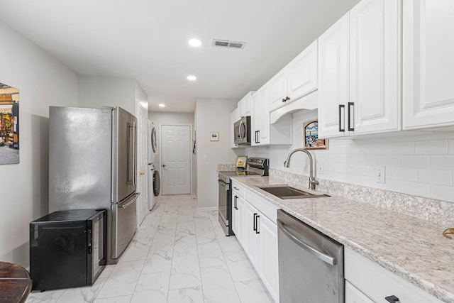 1304 Mallard Dr, Franklin, TN 37064 - kitchen with visible vents, a sink, appliances with stainless steel finishes, backsplash, and marble finish floor