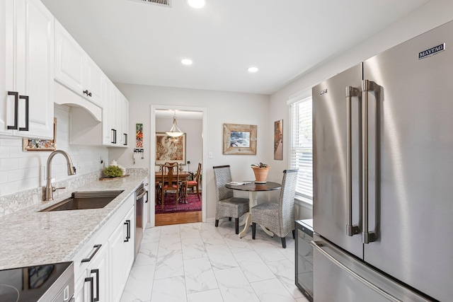 1304 Mallard Dr, Franklin, TN 37064 - kitchen featuring white cabinets, appliances with stainless steel finishes, marble finish floor, a sink, and decorative backsplash