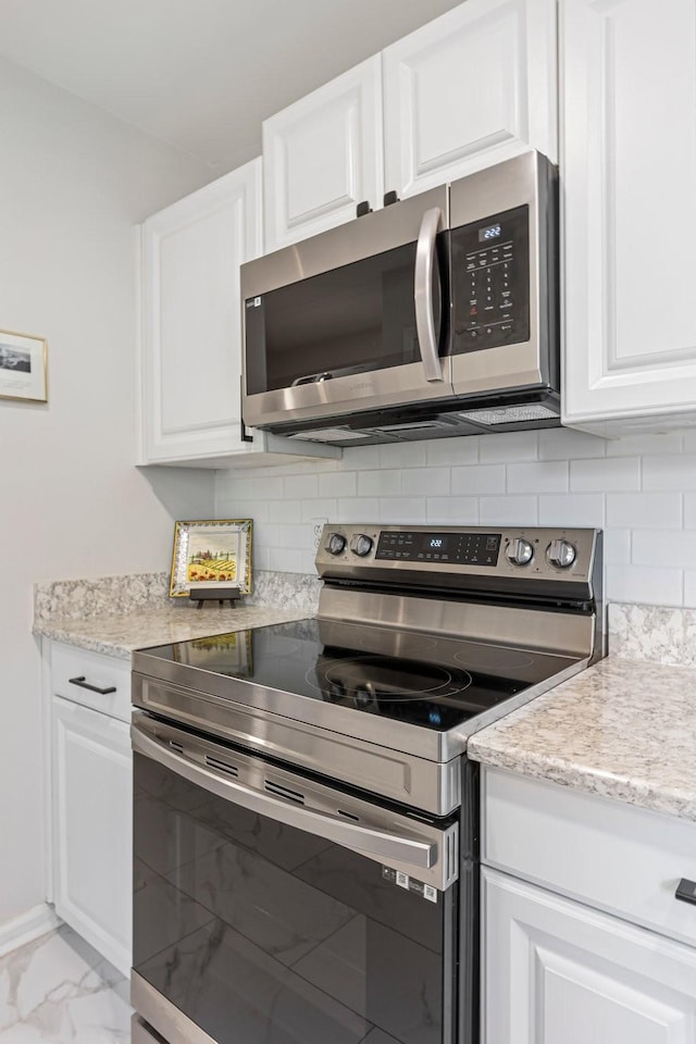 1304 Mallard Dr, Franklin, TN 37064 - kitchen featuring tasteful backsplash, white cabinets, appliances with stainless steel finishes, marble finish floor, and light stone counters