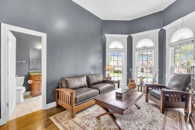living room with a healthy amount of sunlight, crown molding, and wood finished floors