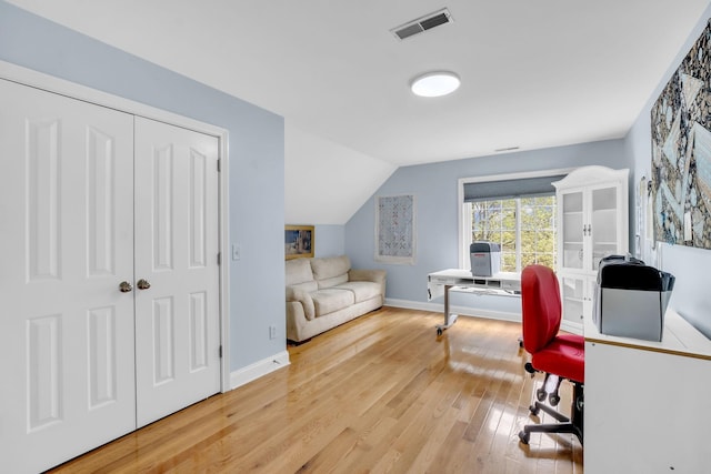 office with visible vents, baseboards, vaulted ceiling, and hardwood / wood-style flooring