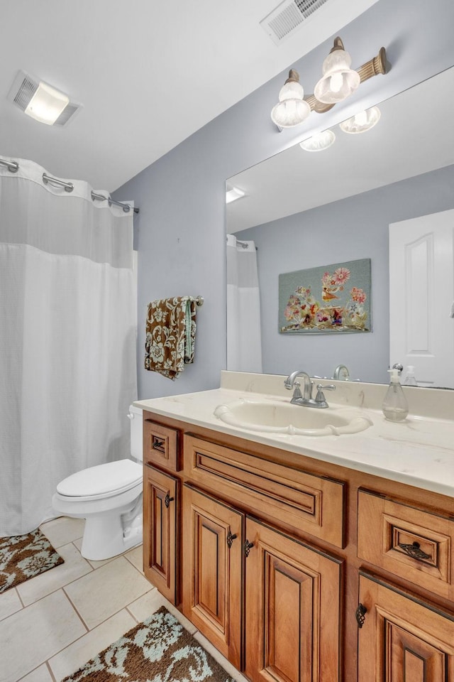 bathroom with toilet, visible vents, tile patterned floors, and vanity