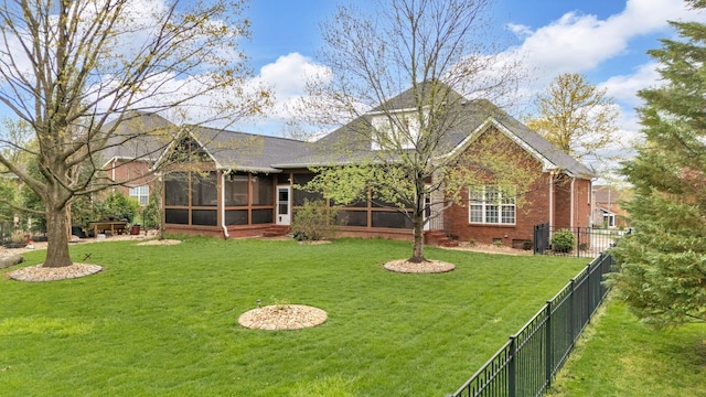 back of property with brick siding, fence, a sunroom, and a lawn
