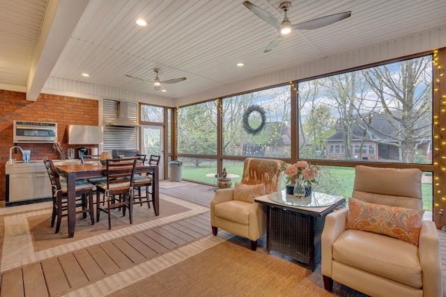 sunroom / solarium featuring ceiling fan, outdoor dining space, and an outdoor kitchen