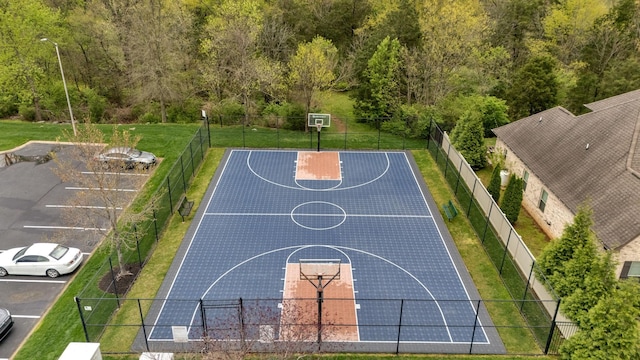 view of sport court with community basketball court, fence, and a yard