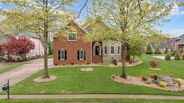 traditional-style home featuring brick siding and a front lawn
