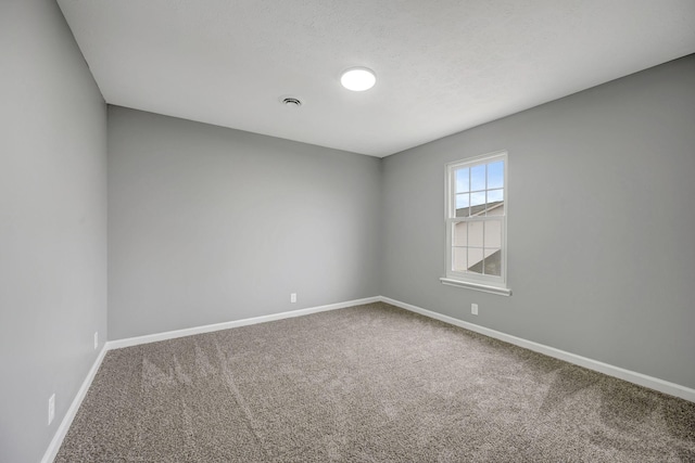 unfurnished room with carpet flooring and baseboards