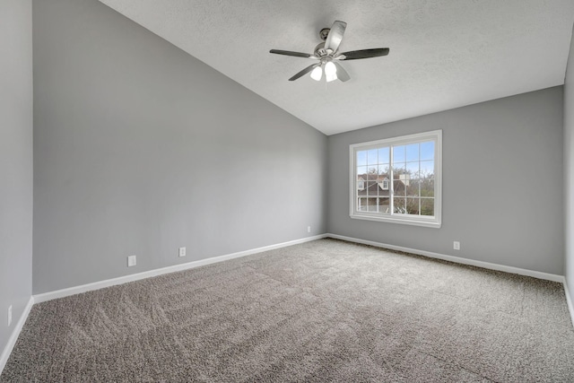 carpeted spare room featuring baseboards, vaulted ceiling, a ceiling fan, and a textured ceiling