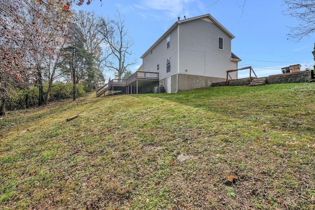rear view of property with stairs, a yard, a wooden deck, and central AC