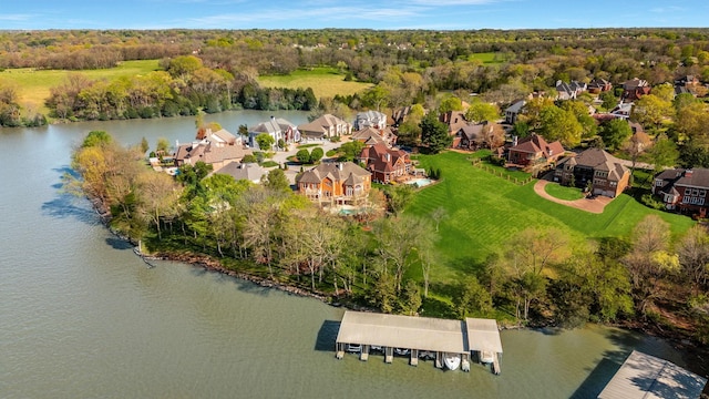 drone / aerial view featuring a residential view, a view of trees, and a water view