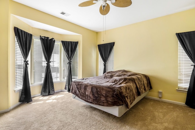 bedroom featuring carpet flooring, visible vents, baseboards, and a ceiling fan