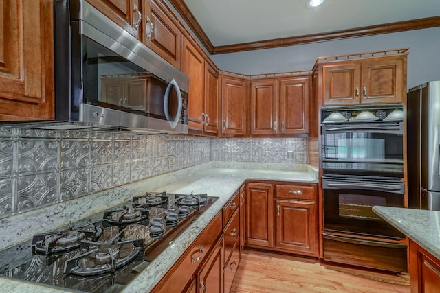 107 Geers Ct, Lebanon, TN 37087 - kitchen featuring ornamental molding, light wood-style floors, brown cabinetry, a warming drawer, and black appliances