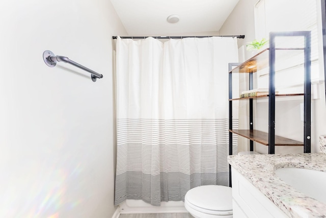 full bathroom featuring toilet, shower / tub combo with curtain, and vanity