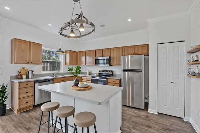 kitchen featuring a sink, light countertops, ornamental molding, and stainless steel appliances
