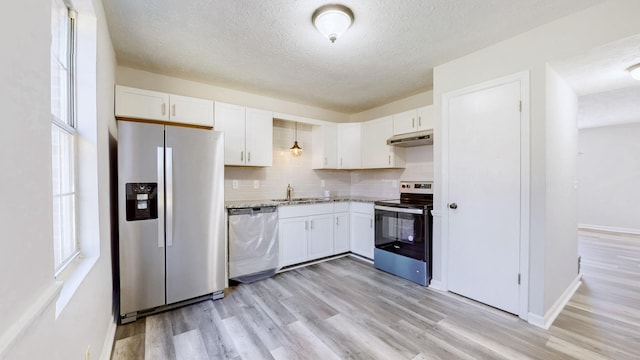 kitchen with light wood-type flooring, white cabinetry, under cabinet range hood, stainless steel appliances, and a sink