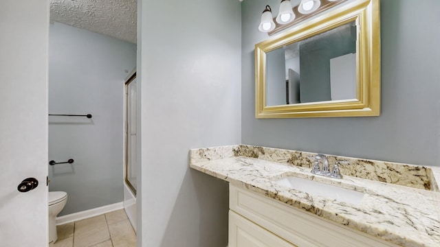 bathroom featuring baseboards, toilet, a textured ceiling, vanity, and tile patterned flooring