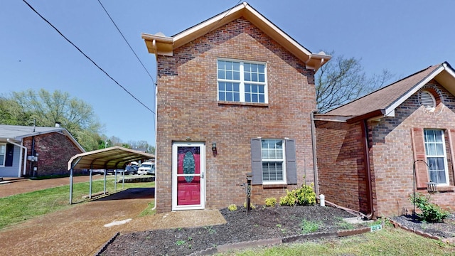 traditional-style home with a carport, driveway, and brick siding