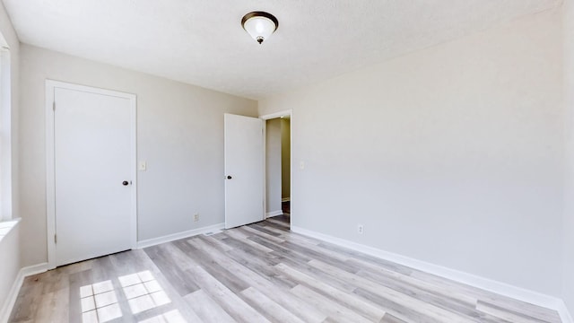 unfurnished bedroom with baseboards and light wood finished floors